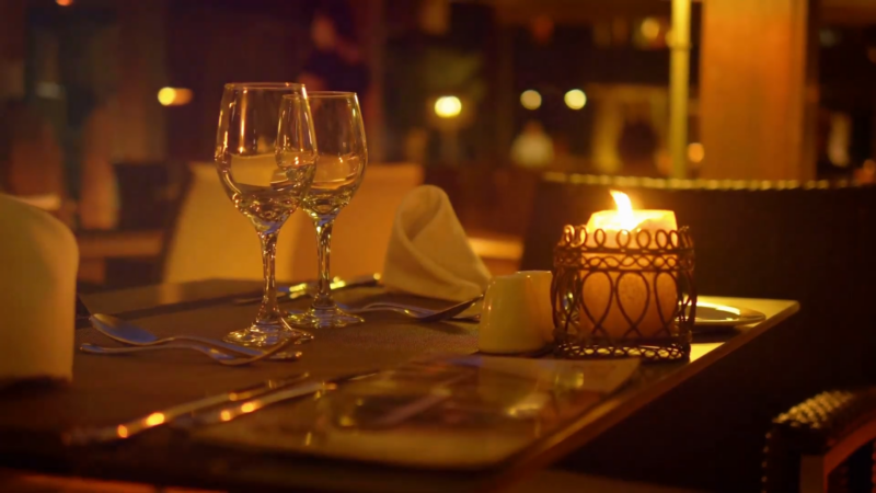 A Beautifully Set Table with Wine Glasses and A Lit Candle Creates an Inviting and Cozy Atmosphere at The Exchange Restaurant in LA