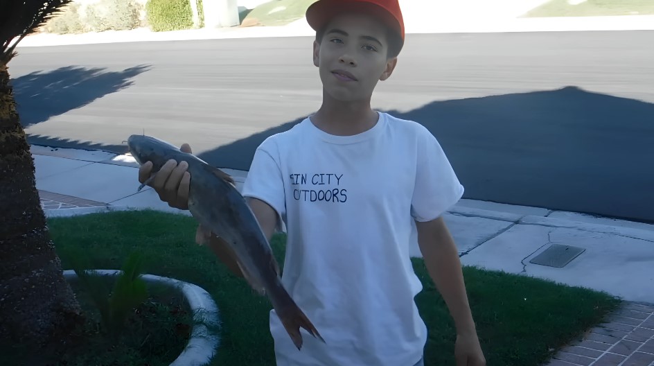 A young angler displays his prize catch