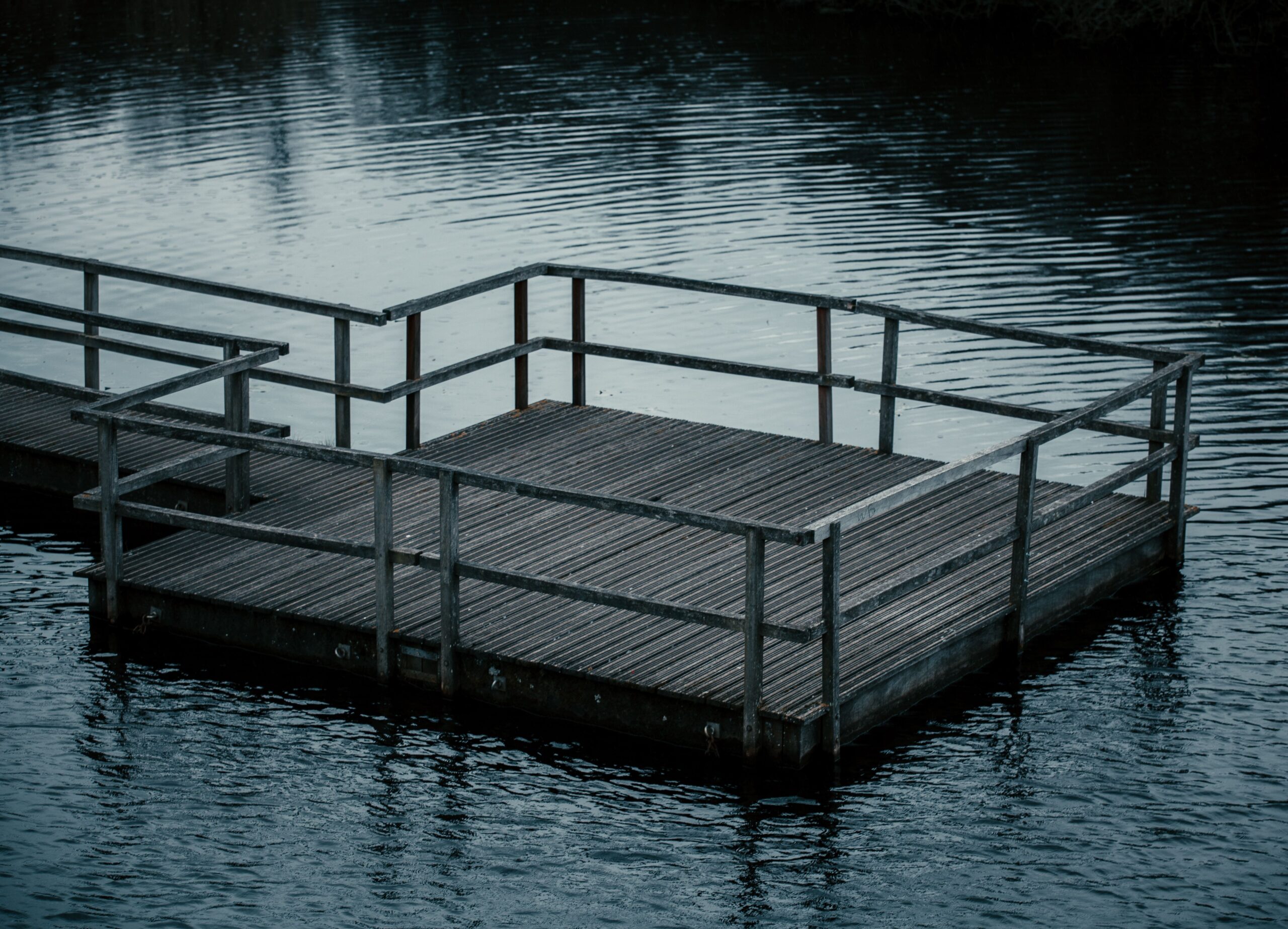 Wooden dock extending into a calm pond, a peaceful spot for relaxing by the water