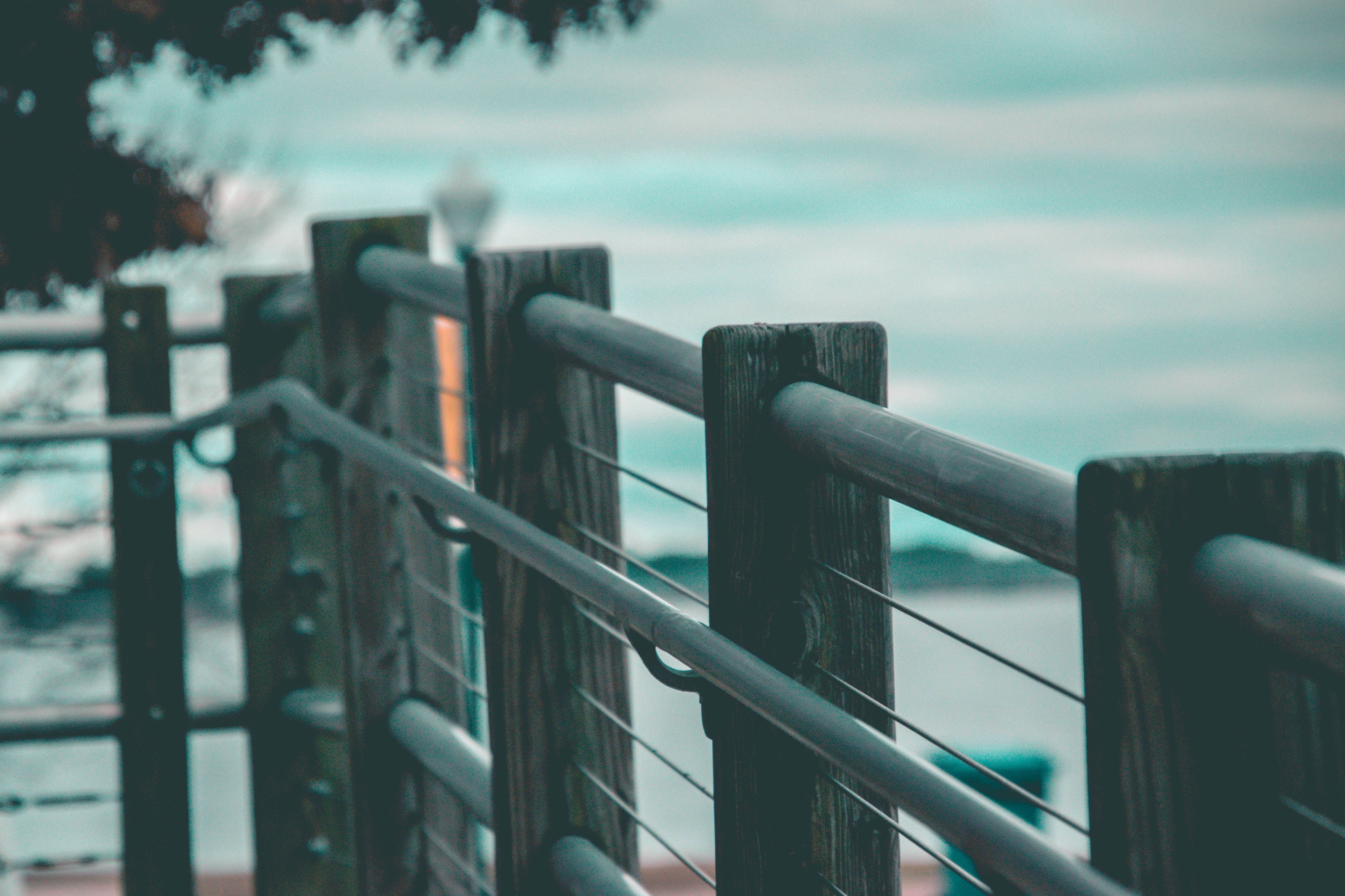 Wooden and steel handrails on a coastal boardwalk overlooking the ocean